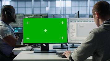 Engineer in server hub using green screen PC to repair equipment storing datasets. Professional using mockup computer to do debugging on rigs doing computational operations, camera A photo