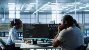 Sick IT professional in server hub sneezing while shielding data from potential threats using PC. Ill employee suffering from flu safeguarding data center against unauthorized access, camera A photo