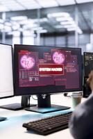 System administrator in server hub working to protect equipment from hacker. Close up of IT worker in data center establishment in need of help from engineers to fix security breach alert photo