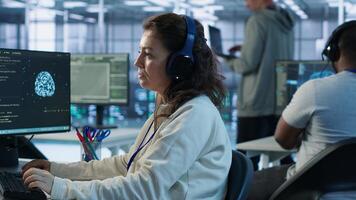Developer listening music while programming in AI data center used for machine learning training. IT specialist wearing headphones running code to upgrade artificial intelligence tech, camera A photo