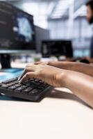 System administrator in server farm using AI systems, typing on keyboard, inputting data. Close up of data center technician using artificial intelligence parallel processing tech on computer photo