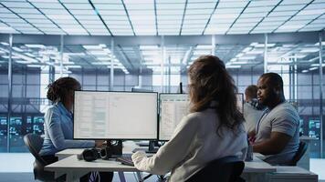Admin arriving in server hub, sitting at computer desk, checking recovery plan, monitoring data center energy consumption across components, making sure sensors are functioning optimally, camera B photo