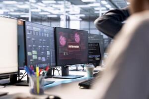 Server hub colleagues cooperating to protect hardware from hacker attack stealing info. Group of data center programmers trying to erase virus after seeing security breach alert on monitor photo