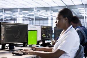 Worker using isolated screen tablet to check for signs of failure in data center supercomputers. Technician working on chroma key device to prevent damages in server farm, monitoring systems photo