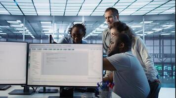 Multiethnic team of engineers working in server hub, using PCs to analyze data. Multiracial group of employees examining infrastructure in data center, ensuring system integrity and security, camera B photo