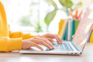Hispanic boy actively attending virtual classes with laptop in a colorful learning environment photo