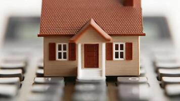 Macro photography of miniature house model on calculator real estate value assessment professional perspective photo