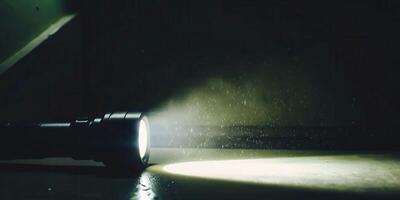 Power outage scene flashlight casting angled beam in darkness scattered objects on floor photo