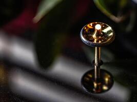 Closeup of a vibrant flame reflecting on a shiny pin minimalistic black background photography concept photo