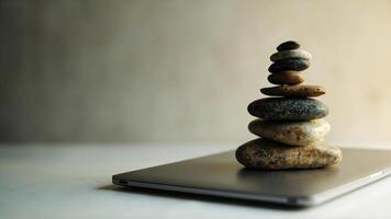 Balanced stones stacked on laptop representing equilibrium and wellness concept photo