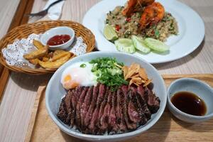 Wagyu beef rice served with stir fry shrimp rice and fried potato wedge photo