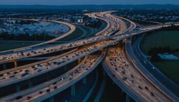Aerial View of Busy Highway Interchange at Dusk with Flowing Traffic and Illuminated Roads photo
