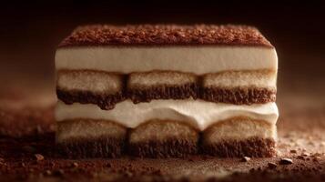 Layered dessert with creamy filling and cocoa powder on top, displayed against a dark and blurred background photo