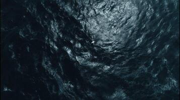 Aerial View of Dark Blue Ocean Waves with a Single White Seagull Soaring Above the Surface in Bright Sunlight photo