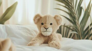 A stuffed animal sits on a bed next to a plant photo