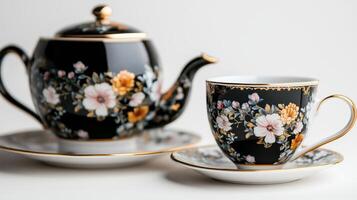 A black and gold tea set with a flower pattern photo