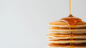 A stack of pancakes with syrup being poured over them photo