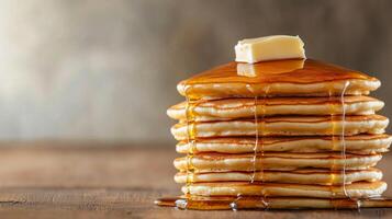 A stack of pancakes with butter and syrup photo