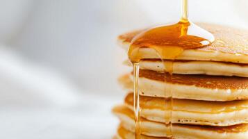 A stack of pancakes with syrup being poured over them. photo