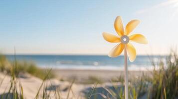A yellow and white windmill on the beach photo