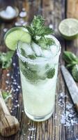 Refreshing classic mojito with lime and mint garnish on rustic wooden table photo