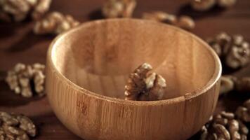 Walnuts fall into a wooden bowl. Filmed on a high-speed camera at 1000 fps. High quality FullHD footage video