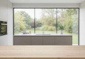 Wooden table in front of kitchen with large window photo