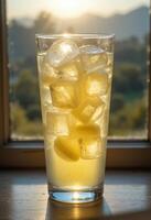a glass of lemonade with ice cubes on the table photo