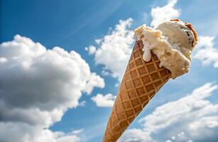 ice cream in a cone. A mouthwatering ice cream cone that stands out against the bright blue sky. photo