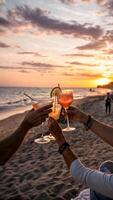 cocktail. Romantic moment on the beach during sunset people's hands clink glasses with refreshing cocktails photo