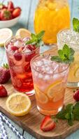 A sparkling collection of refreshing non-alcoholic summer cocktails. Fruit juices, ice cubes of various shapes photo