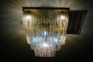 Elegant crystal chandelier illuminating a dimly lit room creating ambience photo