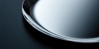Close-up of a shiny metal tray on a dark surface reflecting light photo