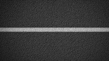 Close-up view of gray asphalt road with white divider line for urban concept photo