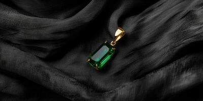 Elegant green gemstone pendant on luxurious black fabric surface photo