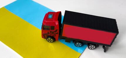 Top view of toy truck on flag of ukraine background, space for text. Logistics and wholesale concept photo