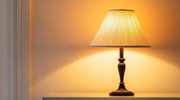 Warm yellow light from a classic table lamp with pleated shade on a nightstand photo