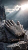 Grey gloves on rocky mountain with dramatic sunlight, symbolizing adventure photo