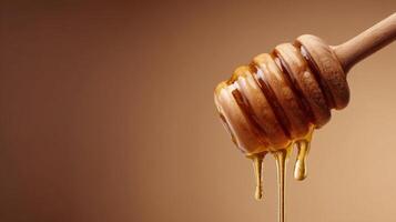 Honey dipper with golden liquid honey against a brown background photo