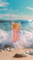 Refreshing lemonade with pink straw on beach in ocean surf waves photo