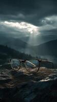 Eye glasses on a rocky surface under dramatic cloudy sky in moody landscape photo