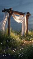 Wooden arch with flowing white fabric in flower field at dusk, magical ambiance photo