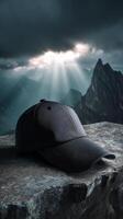 Black cap on stone ledge with dramatic mountain background and sun rays photo