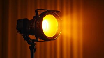 Studio spotlight shining bright with a warm yellow glow in a dark room photo