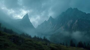 Misty mountains with dramatic clouds surrounding jagged peaks and forest photo
