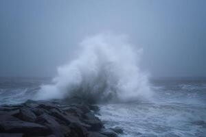 Powerful Waves Crashing Against Rocks on a Stormy Coastline photo