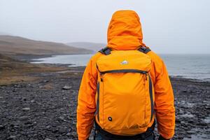 Stunning Outdoor Scene with a Person in a Bright Orange Jacket and Backpack photo