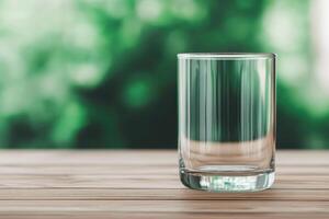 Empty Glass on Wooden Table with Nature Background photo