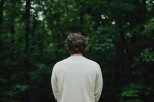 Contemplative Figure Amidst Lush Green Forest A Moment of Serenity photo