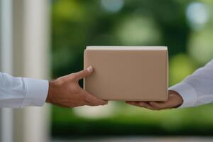 Package Delivery Hands Exchange a Cardboard Box Outdoors photo